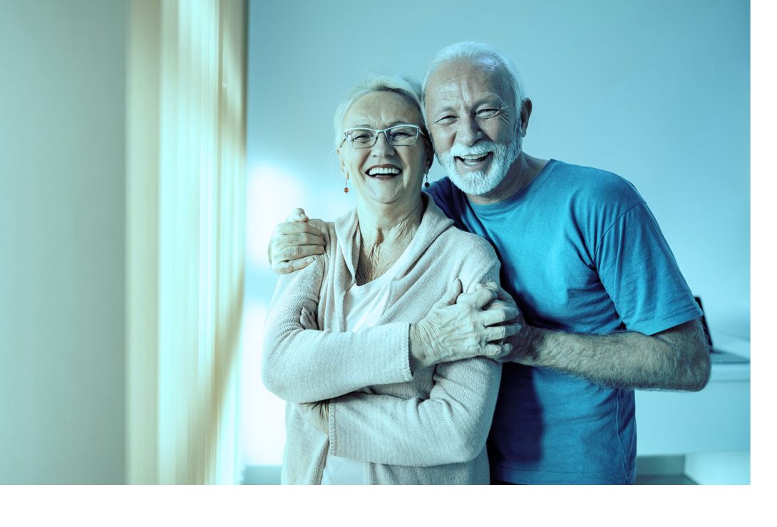 Casal de idosos sorrindo, abraçados